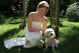A bride poses with her well-behaved pooch
