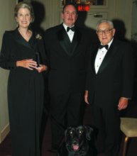 Nancy Kissinger, Detective Raymond Clair with Winston, and Dr. Henry Kissinger.
